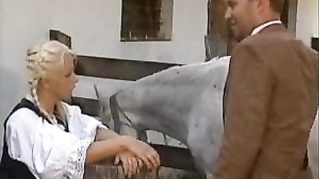 Blonde Anita Paris in traditional dress with man and horse on farm