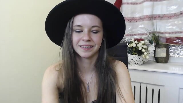 Marice Shine Chaturbate camgirl in black hat smiling topless