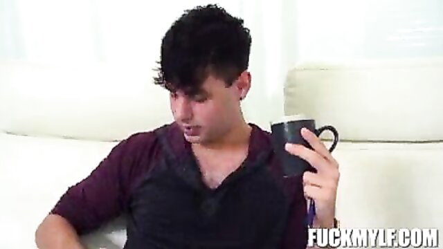 Handsome young man with curly black hair sips coffee on couch in stepmom admirer porn