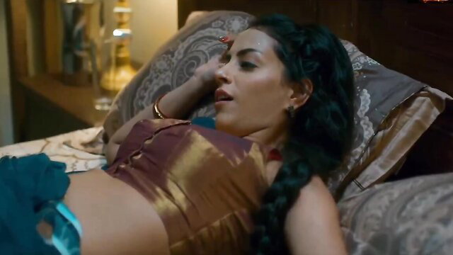 Hot Desi MILF in gold blouse and skirt lounging seductively on bed