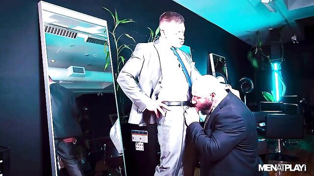 Bruce Beckham gets knelt blowjob from Mark Vallant in barber shop