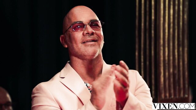Bald handsome man in pink suit clapping on VIXEN set In Vogue 2