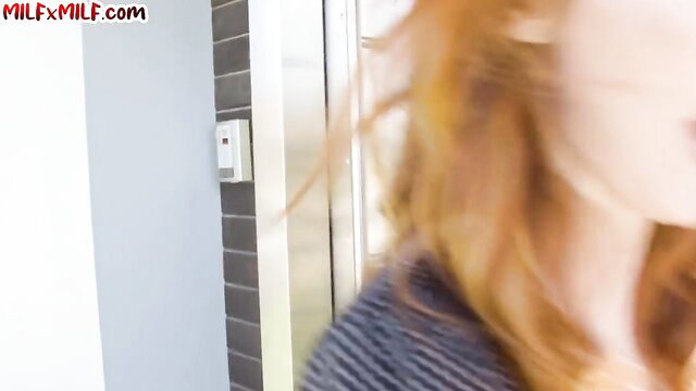 Hot redhead MILF in elevator with striped top, big tits tease