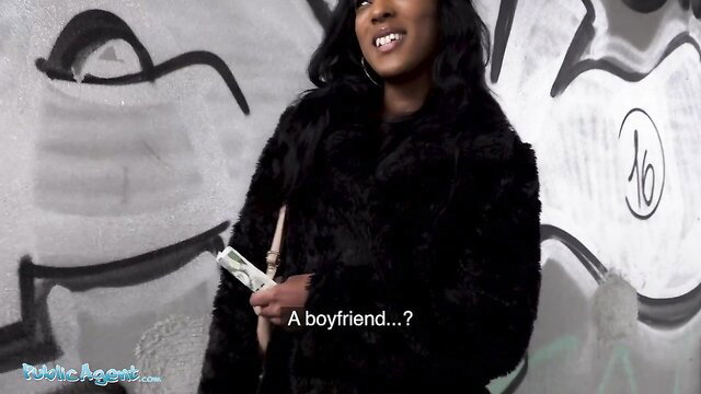 Asia Rae holds cash smirking in fur coat on graffiti wall
