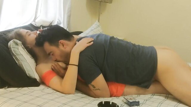 Sensual couple nursing handjob on bed, passionate embrace