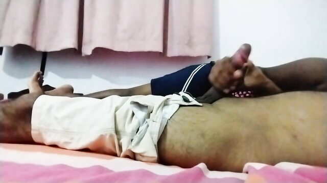 Two Sri Lankan men in shorts foot massage on bed