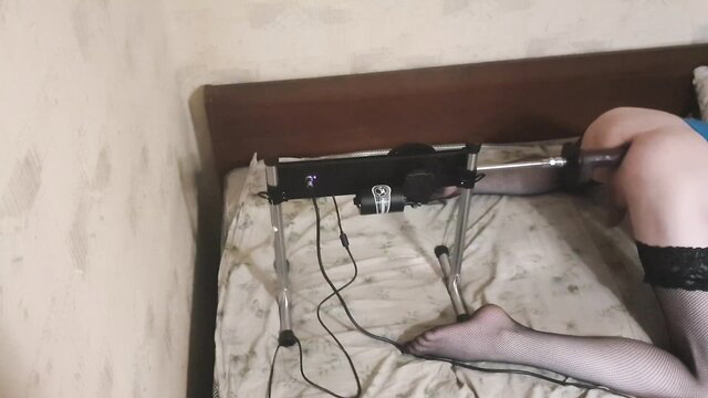 Sissy in stockings fucked by sex machine on bed