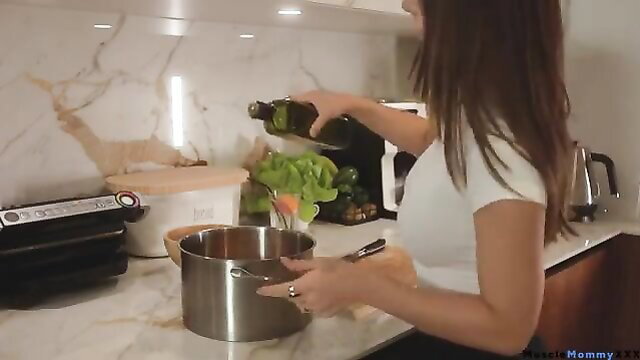 Brunette MILF in tight white top cooking in kitchen daily routine