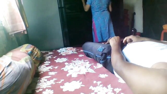 Indian maid in blue saree stands by bed with dark man lying nude