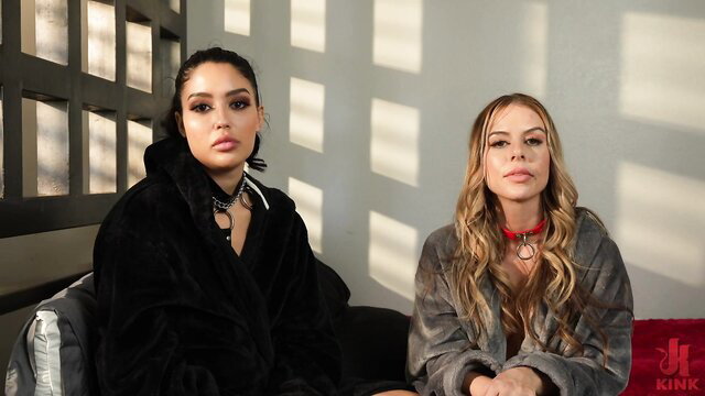 Two busty women in fur robes and collars, teasing anal kink scene