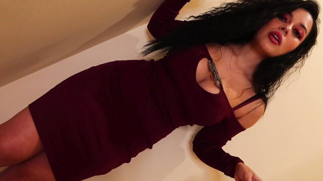 Curvy black-haired Latina in tight burgundy cutout dress poses seductively