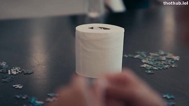 Bonnie Blue with toilet paper roll and puzzle pieces on table