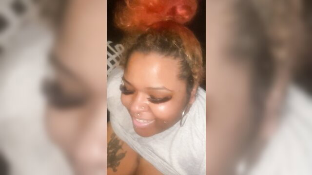 Closeup of sexy black BBW with orange hair smiling in towel