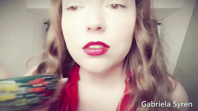 Gabriela Syren closeup with red lips, green toy and red scarf