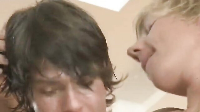 Blonde mature woman whispering to young man in closeup intimate moment