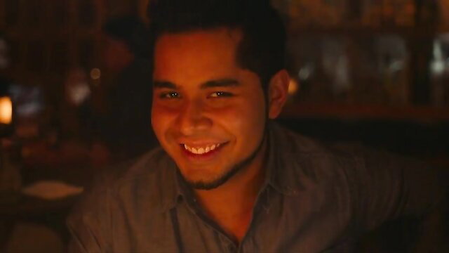 Handsome Latino man smiling in dim bar - Corazonada 2022 celeb scene