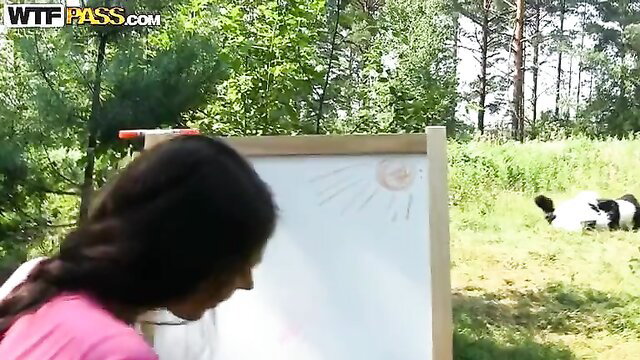 Cute brunette in pink top with funny panda outdoors by easel
