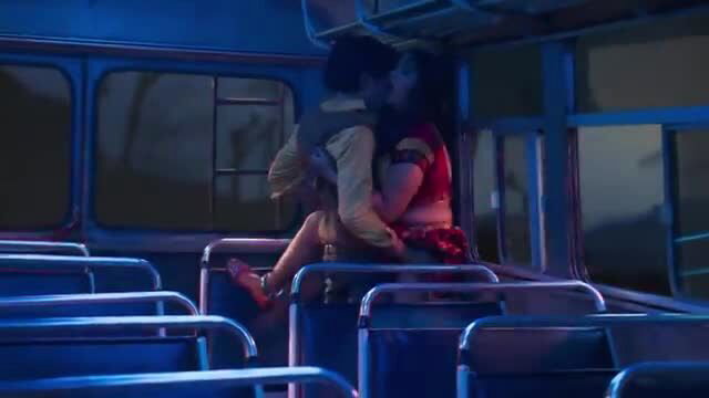 Steamy bus embrace: man hugs woman in red dress intimately