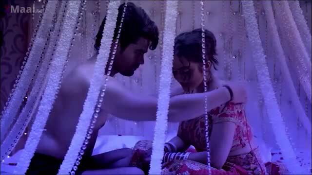 Indian bride dulhan in passionate embrace with shirtless groom on bed