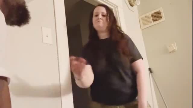 Ally in black t-shirt and cargos grabs at door with bearded guy