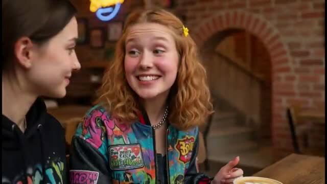 Two cute teen college girls with curly red hair smiling at diner party