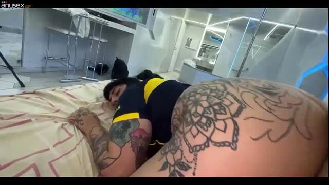 Tattooed woman in body paint lying prone, ass focus