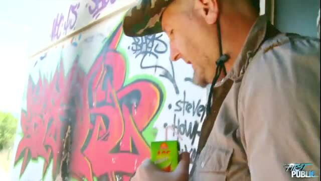 Man in cap and jacket drinking juice near colorful graffiti