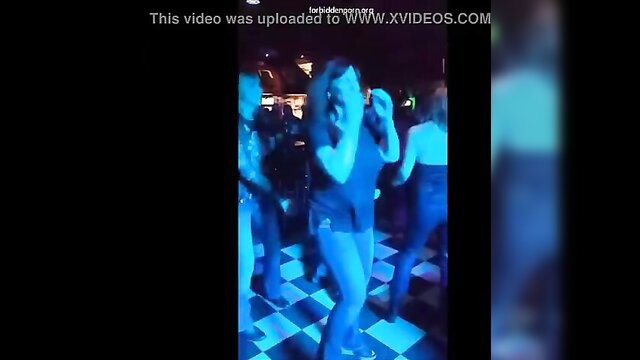 MILF flashing big tits on stage at neon-lit concert party