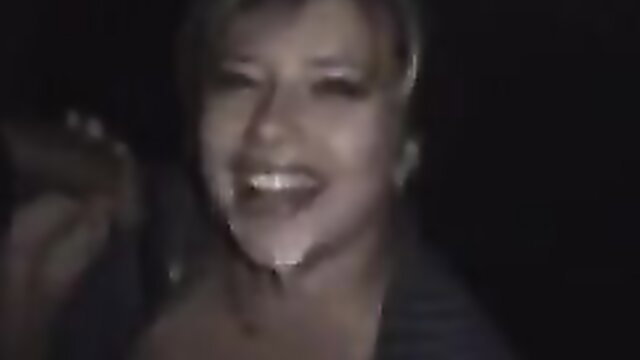 Mature blonde slut smiling with cum on face in dark parking lot