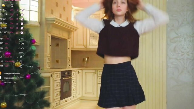Cute redhead camgirl in plaid miniskirt and vest poses sexy live stream