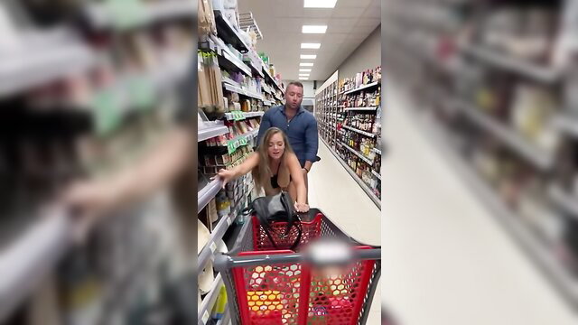 Hot babe in lingerie rides shopping cart pushed by man in supermarket