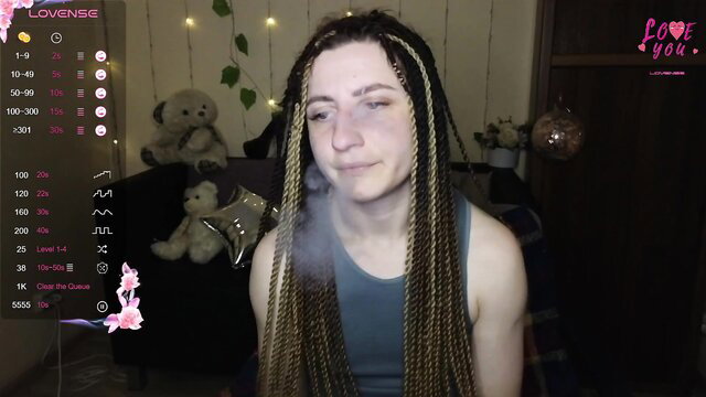 Trans girl Jenia with braids exhales vape smoke on Chaturbate stream