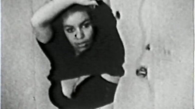Vintage brunette peeking through wall hole with tits exposed