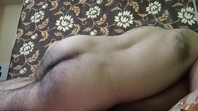Muscular Indian man lying nude on bed, bare ass exposed