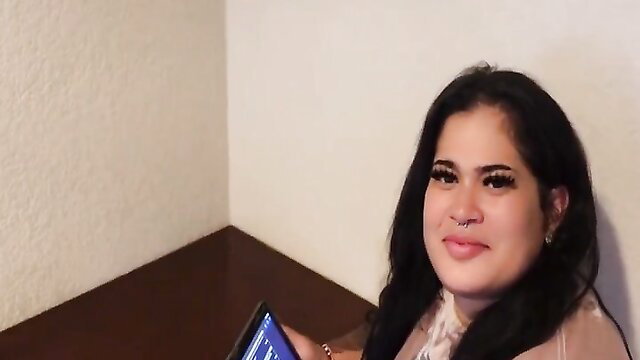 Hot Latin BBW with bold makeup smiles holding phone in sheer top