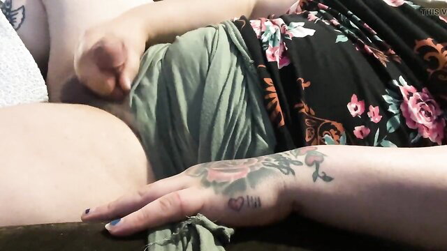 Tattooed curvy woman lifting dress exposing belly and ass in teasing pose