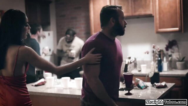 Hot Latina in red backless dress grabs bearded guy's shoulder in kitchen party