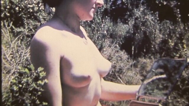 Vintage granny nude in bushes holding mirror, bare tits outdoor