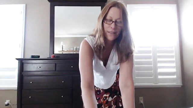 Blonde MILF in low-cut top and skirt smiles seductively on webcam