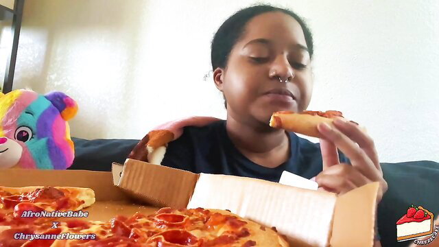 Thick black girl eating pizza in mukbang style, tiny snacks on top