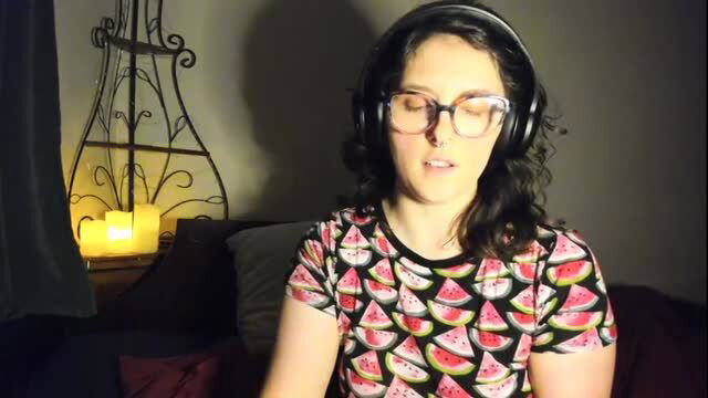 Brunette in glasses and watermelon shirt with headphones, eyes closed