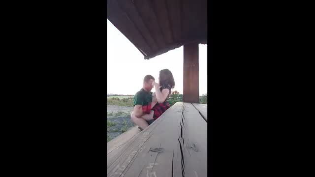 Couple having sex outdoors on wooden platform