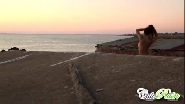 Naked teen babe shows off her tits outdoors at sunset
