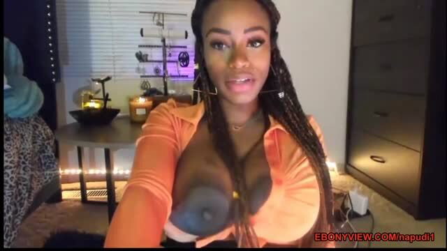 Ebony woman with massive black boobs in orange top