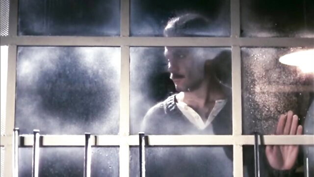 Vintage 1975 man peering through foggy rainy window, moody noir scene