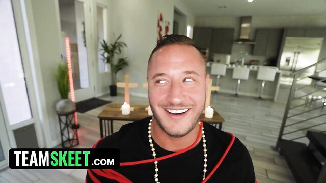 Bald muscular man smiling in priest outfit with crosses, lustful nuns theme