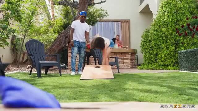 Busty MILF Nika Venom bent over in tiny shorts playing cornhole