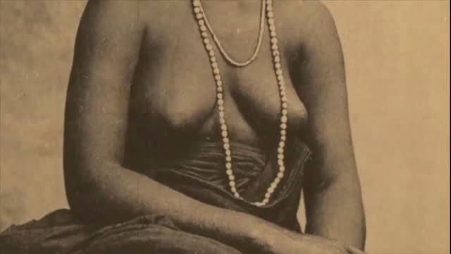 Vintage nude African woman with beaded necklace, topless sepia photo