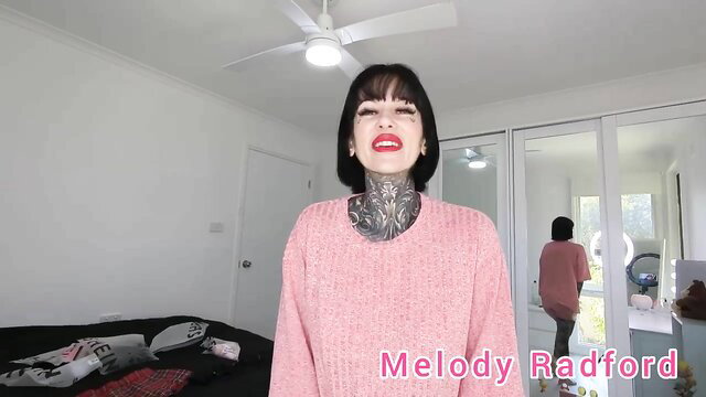 Melody Radford smiling in pink sweater with neck tattoos, lingerie try-on
