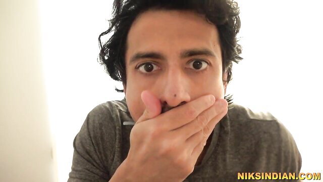 Handsome Indian man with curly hair shocked expression closeup